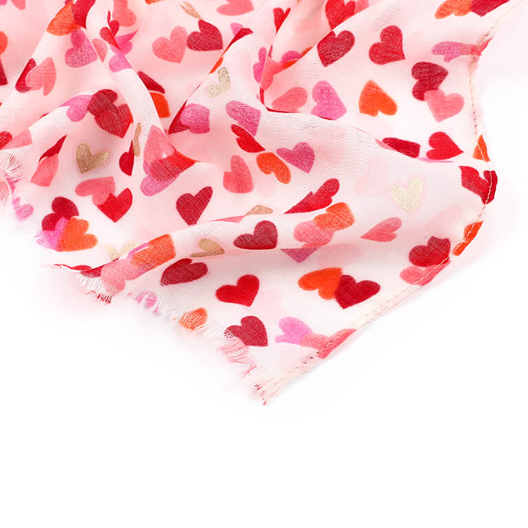Detail van roze sjaal met rode, roze en goudkleurige hartjes