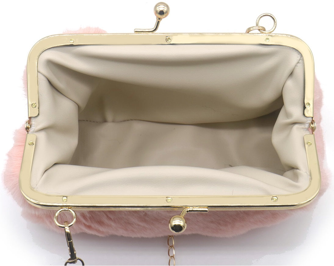 Binnenkant van roze fluffy clutch met lichte voering en goudkleurige beugelsluiting