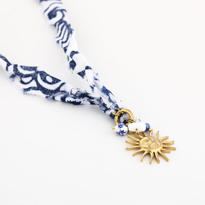 Stoffen ketting blauw wit met goudkleurige zon bedel - Medase