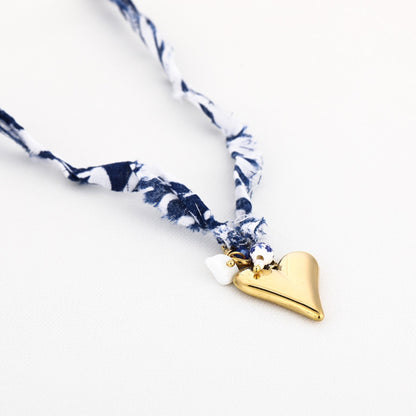 Detailfoto stoffen ketting met metalen sluiting gouden hart en bedels